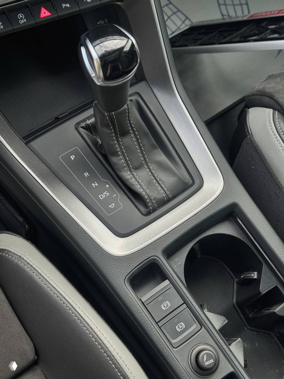 Руль Audi с логотипом, цифровая приборная панель с отображением меню и пробега; хороший ракурс на органы управления на руле.