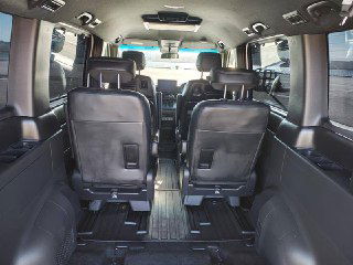 Внутренний обзор салона Honda StepWGN Spada 2024 от задней двери к передним сиденьям, три ряда кресел, пространство для багажа видно.