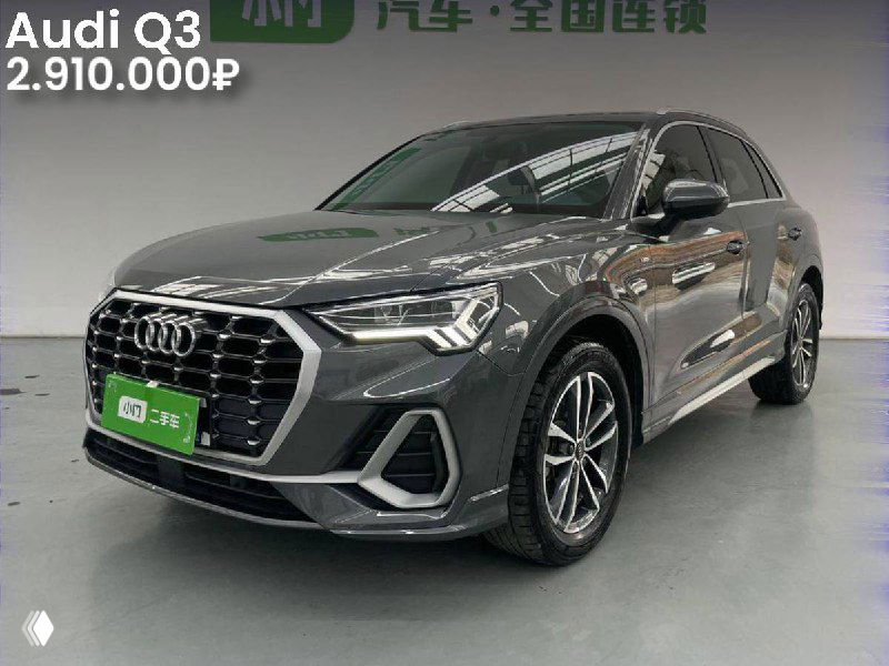 Трёхчетырёхчетвертное фото серого Audi Q3 в салоне; видна боковая линия и диски, пробег 27 000 км и цена 2.910.000₽