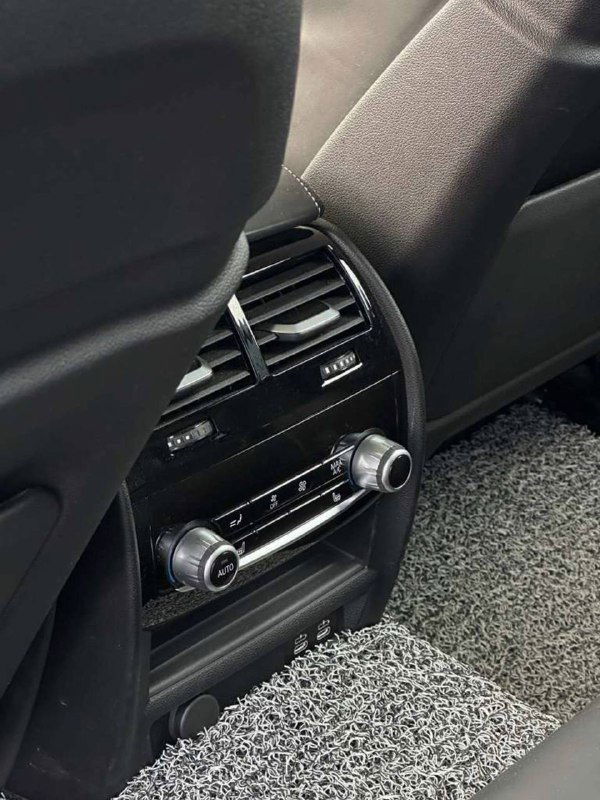 Задняя часть центральной консоли BMW с вентиляционными дефлекторами и панелью управления для задних пассажиров — крупный план функционала.