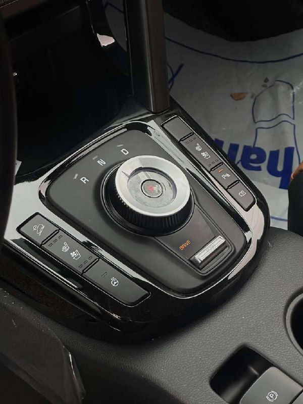 Центральная консоль KIA Seltos: селектор коробки передач в виде шайбы, кнопки режимов и отделка вокруг подстаканников.