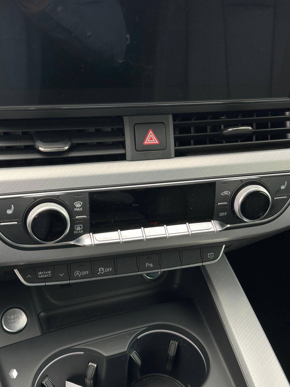 Фрагмент передней панели с кнопками обогрева, аварийной сигнализации и элементами климат-контроля в интерьере Audi