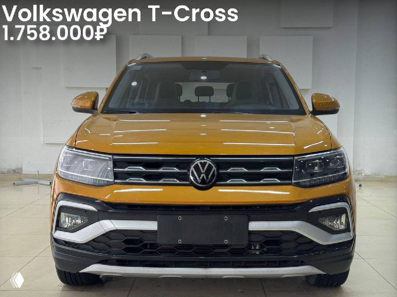 Фотография оранжевого Volkswagen T‑Cross в выставочном помещении, вид спереди; чётко видны фары, бампер и подпись цены 1.758.000₽.