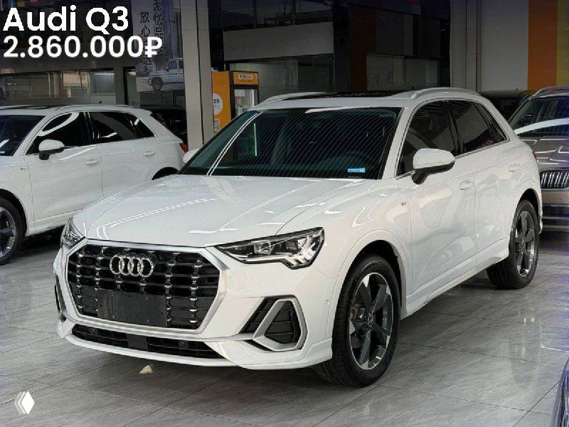 Белый Audi Q3 на площадке дилерского центра в Китае: боковой и фронтальный ракурс, заметен дизайн фальшрадиаторной решётки и цена в углу.