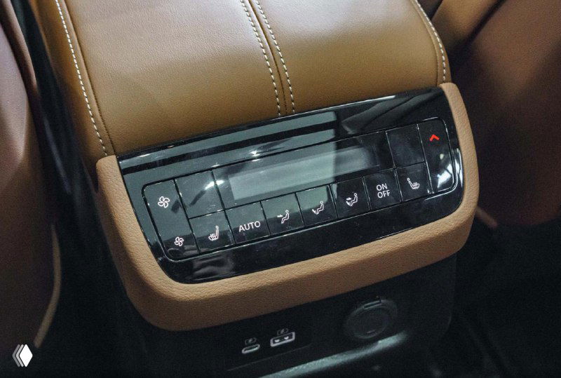 Панель климат-контроля для задних пассажиров Infiniti QX60 — крупный план элементов управления и разъёмов зарядки в центральной консоли.