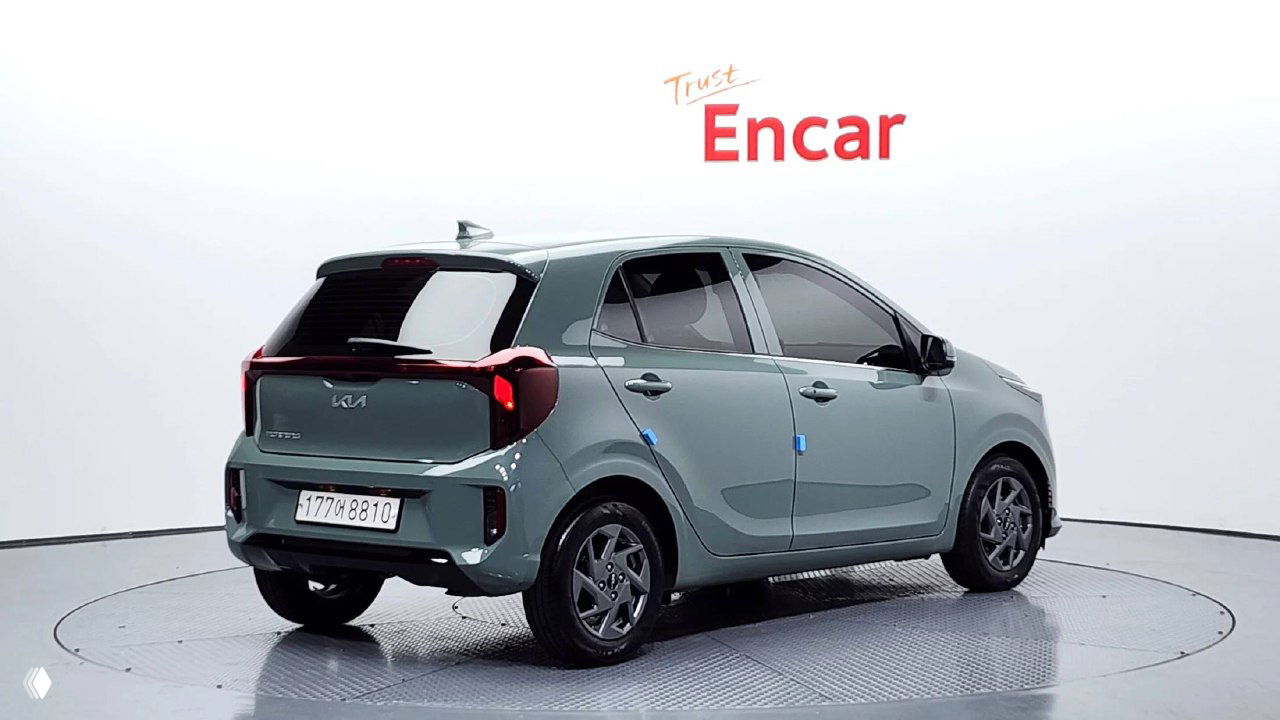 Вид сзади рестайлингового KIA Morning 2025 в шоуруме Encar: задние фонари, багажная дверь и форма заднего бампера на поворотной площадке.