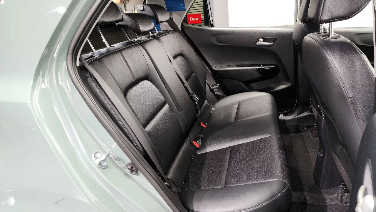 Задний ряд сидений рестайлингового KIA Morning 2025: чёрная обивка, три ремня безопасности и укладка заднего пассажирского места.