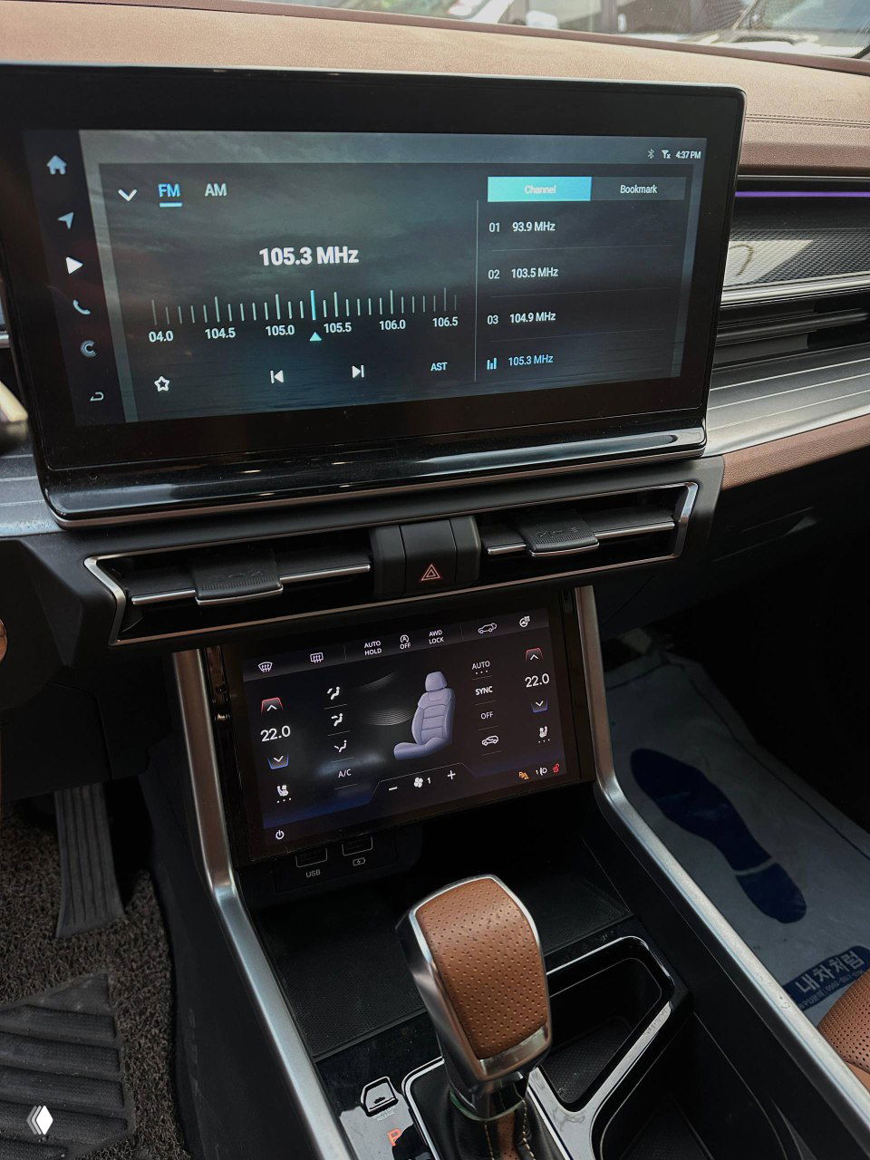 Информационно-развлекательный экран и панель управления SsangYong Torres, крупный план дисплеев и элементов климата, видны цифровые меню и сенсорный экран.