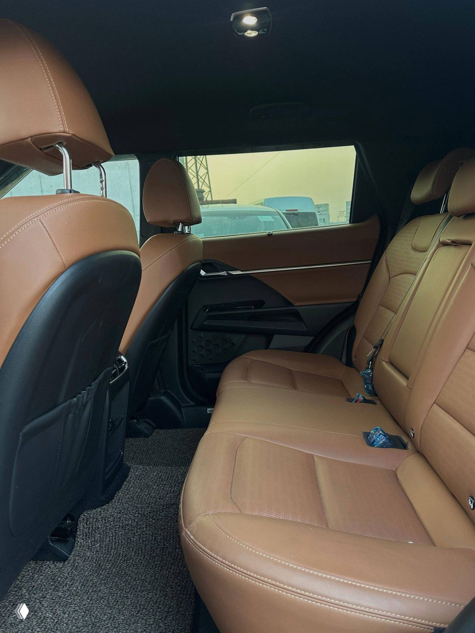 Задний ряд и интерьер SsangYong Torres, коричневые кожаные сиденья и пространство для пассажиров, фото показывает общий вид салона и освещение.