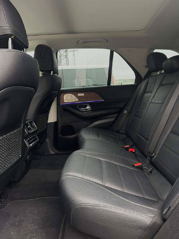 Задний ряд салона Mercedes GLE 450: кожаные диваны, пространство для пассажиров и общий вид задней части интерьера автомобиля.