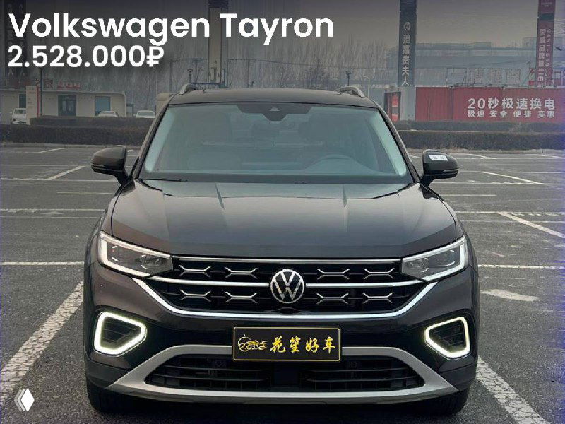 Volkswagen Tayron чёрного цвета на парковке/плаце, крупный фронтальный план с дневными ходовыми огнями и указанием цены 2.528.000₽.