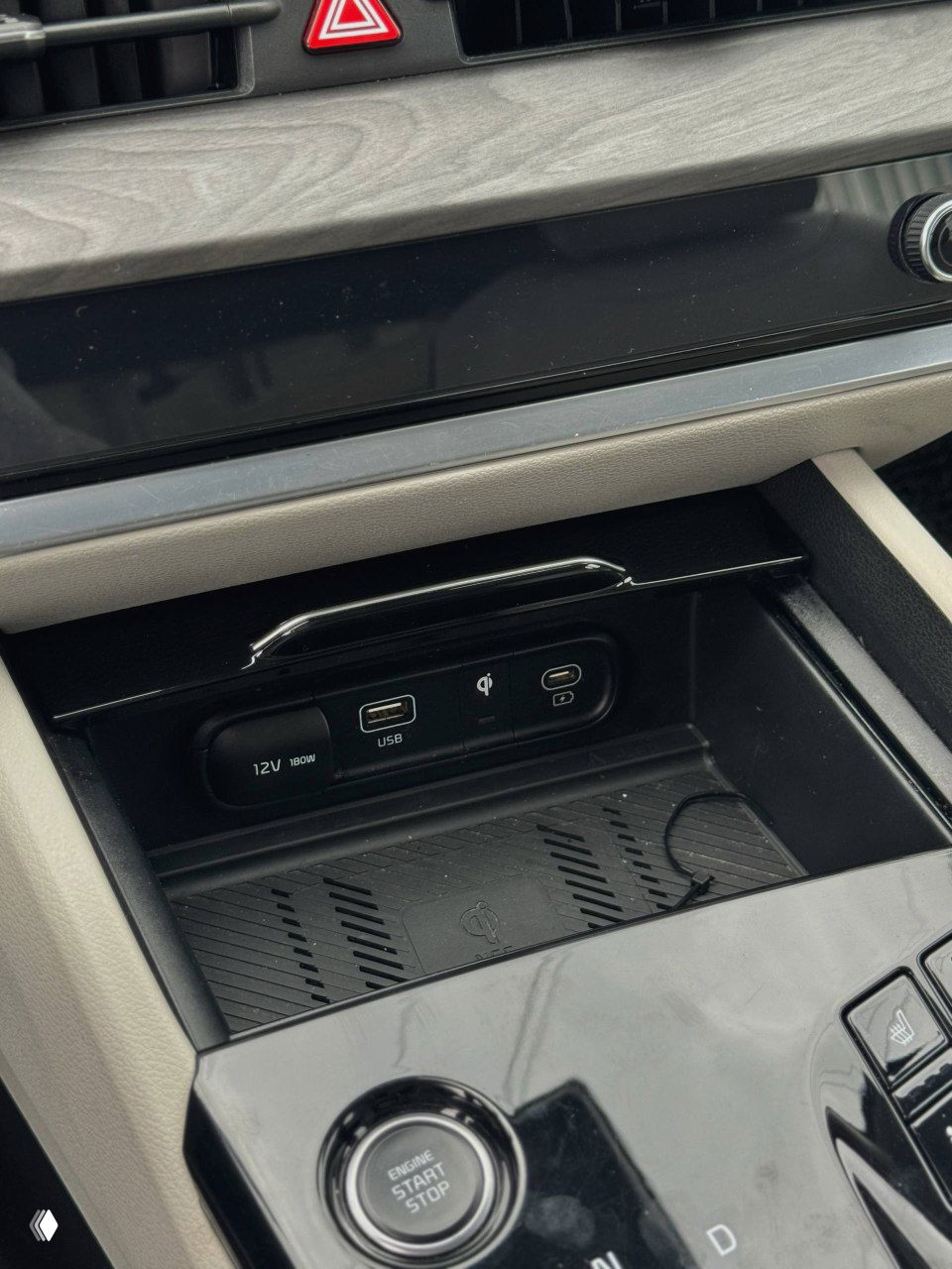 Средняя консоль и подстаканники KIA Sportage, чёрный глянцевый пластик, вид на ручки и небольшие отделения для мелочей, состояние салона аккуратное.