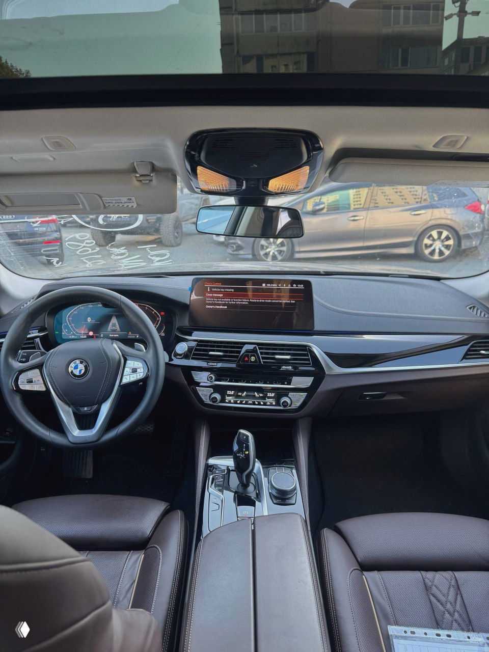 Вид на приборную панель и центральную консоль BMW 530i: цифровая приборная панель, большой мультимедийный дисплей и элементы управления климатом в салоне.