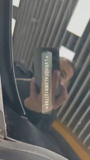 Ещё один видеокадр VIN-пластинки на лобовом стекле Mazda 3 Axela, видна идентификационная табличка автомобиля и отражение интерьера автосалона.