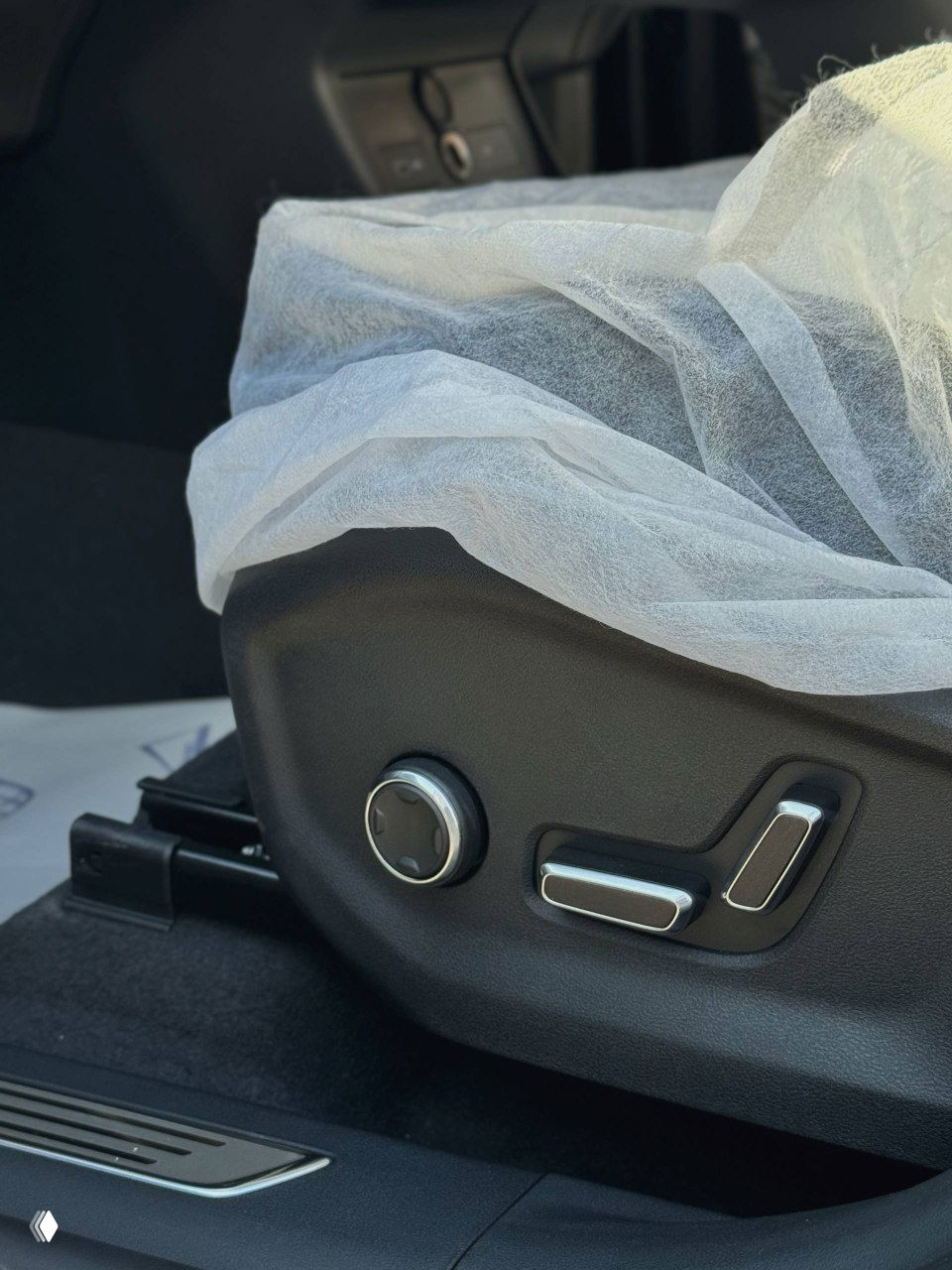 Крупный план электрорегулировок сиденья Geely Monjaro: кнопки регулировки поясничного подпора и положения кресла, видна обивка и пыльник направляющей.