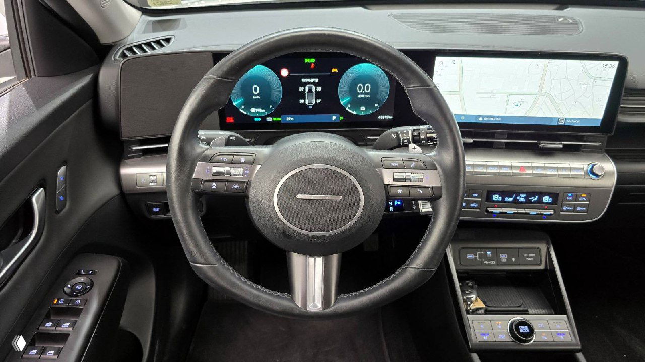 Руль и цифровая приборная панель Hyundai Kona со шкалами и индикаторами, вид на навигационный экран и часть центральной панели крупным планом.