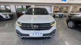 Короткое превью-изображение общего вида спереди Volkswagen Tacqua в автосалоне: свет включён, видны окружающие автомобили и полированное покрытие пола.