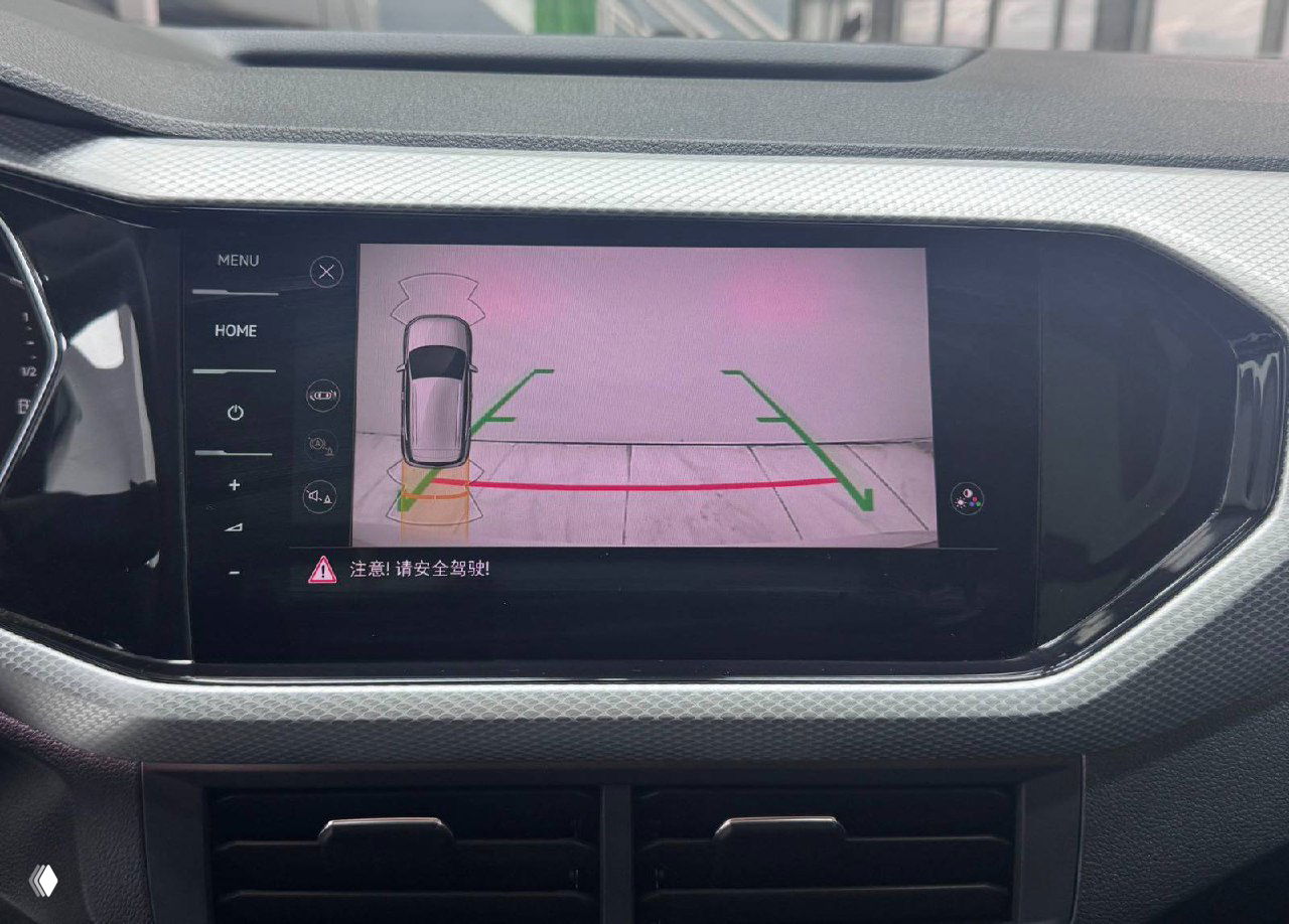 Ещё один крупный кадр экрана мультимедиа Volkswagen Tacqua с обзорной камерой: линии парковки и предупреждающее сообщение на китайском языке.