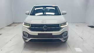 Превью видео с фронтальным видом белого Volkswagen Tacqua в светлой студии: включены дневные ходовые огни, автомобиль снят спереди в полный рост.