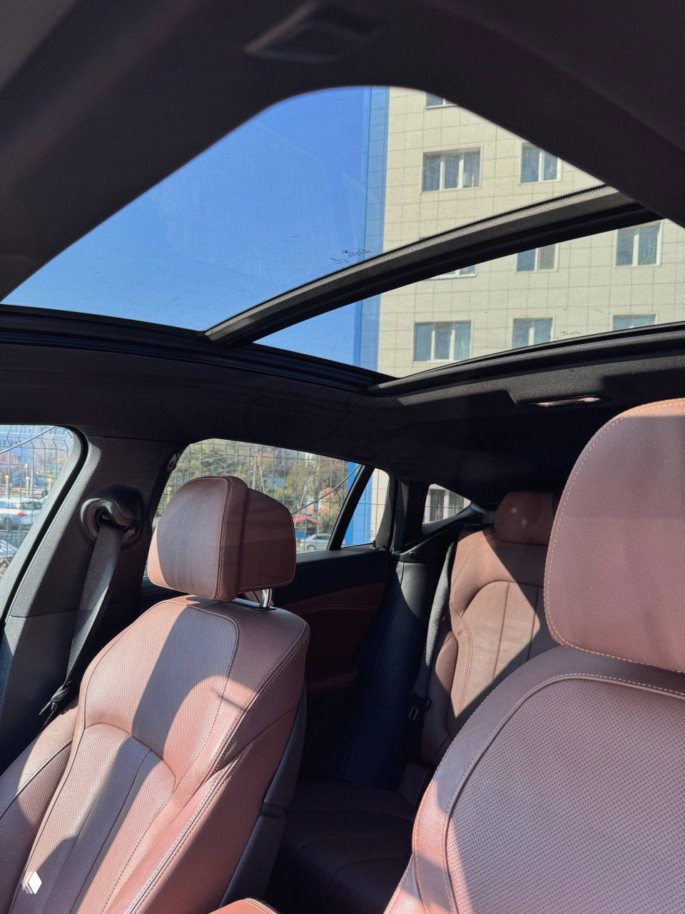 Панорамная крыша BMW X6 и передние сиденья в коричневой коже, общий вид салона сверху с естественным освещением, фото подтверждает наличие люка