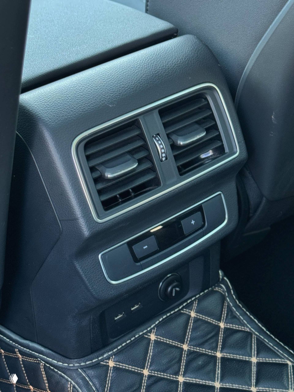 Крупный план воздуховодов и элементов управления для задних пассажиров в Audi Q5L, видны USB-порты и элементы отделки багажного отсека