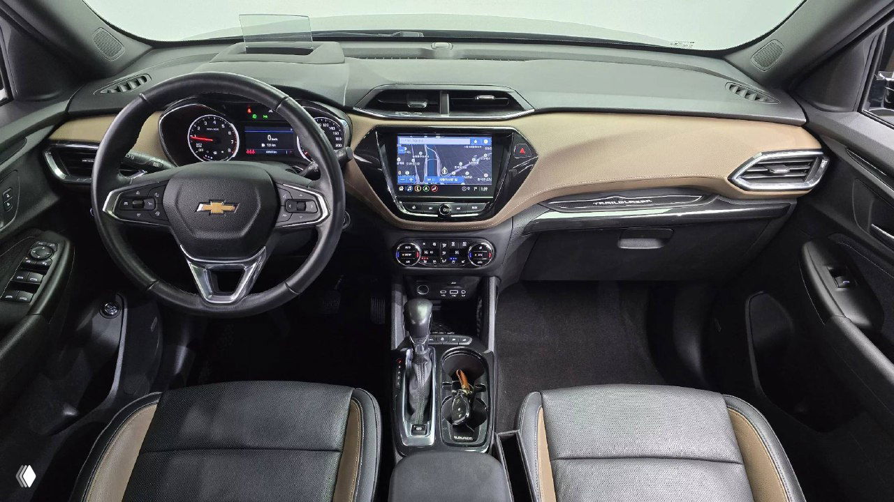 Панорамный снимок торпедо и передней части салона Chevrolet Trailblazer — руль, мультимедиа экран и центральная консоль видны в деталях.