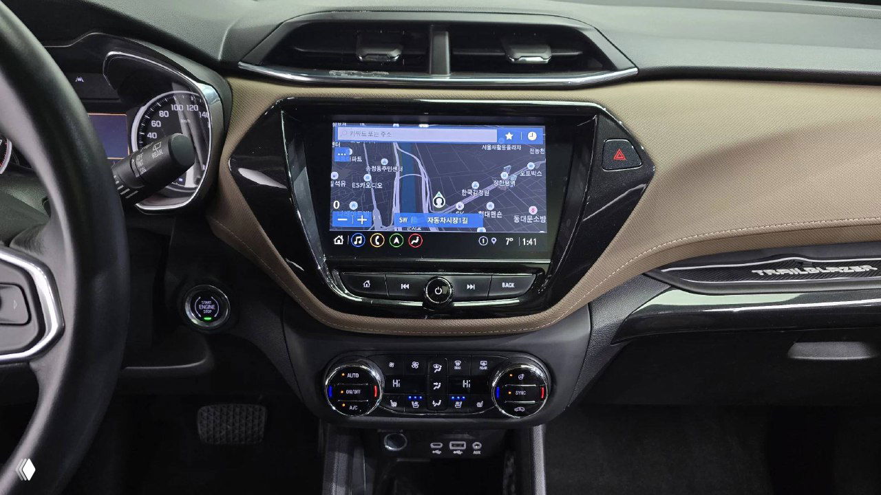 Центральная консоль и мультимедиа система Chevrolet Trailblazer с навигацией на экране, органы управления климатом и портами подключения видны в кадре.