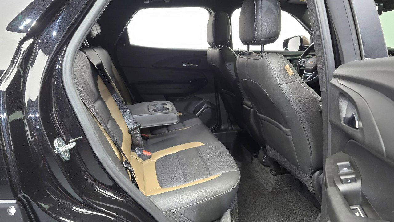 Задний ряд сидений Chevrolet Trailblazer со сложенным подлокотником и подстаканниками, видно пространство для пассажиров и состояние обивки заднего дивана.