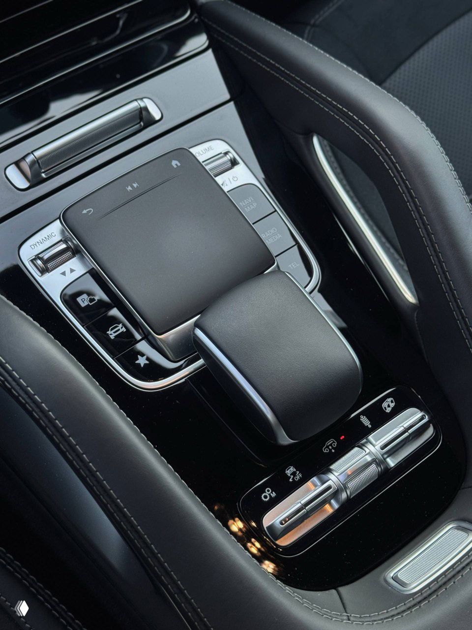 Крупный план центральной консоли Mercedes GLE53 AMG — сенсорная панель управления, селектор коробки и элементы отделки в чёрном глянцевом исполнении.