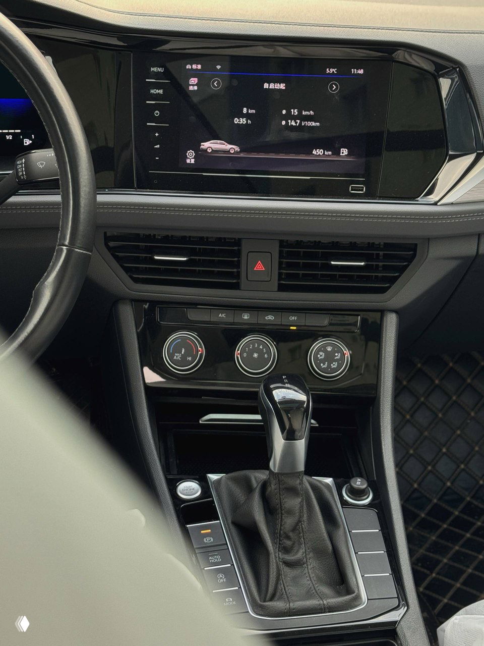 Центральная консоль Volkswagen Sagitar с большим сенсорным экраном мультимедиа, селектором передач и блоком климат‑контроля — вид интерьера спереди.