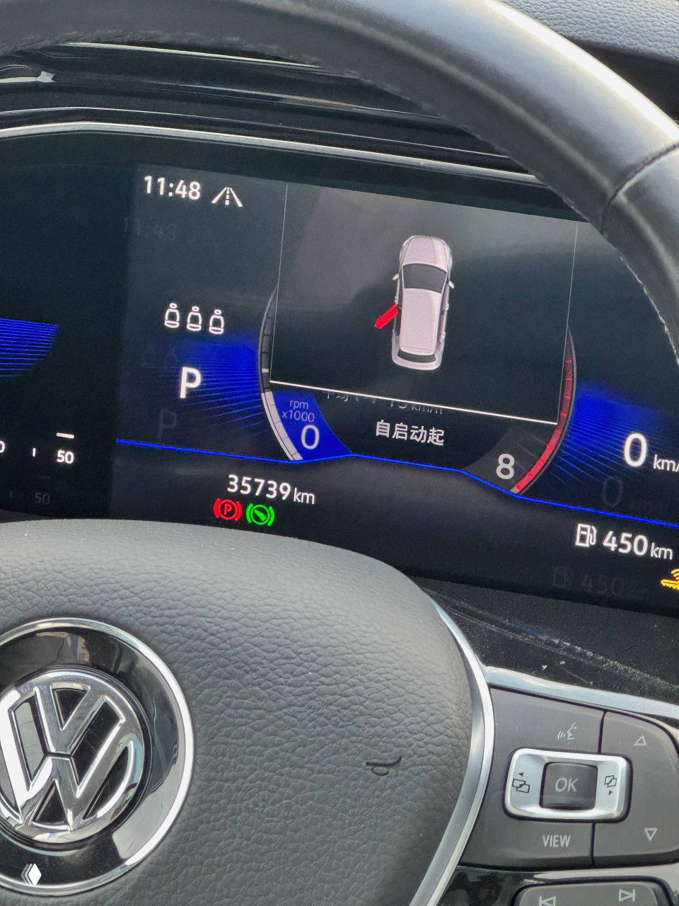 Цифровая приборная панель Volkswagen Sagitar с показанием пробега 35739 км, индикаторами и элементами интерфейса, часть рулевого колеса на переднем плане.