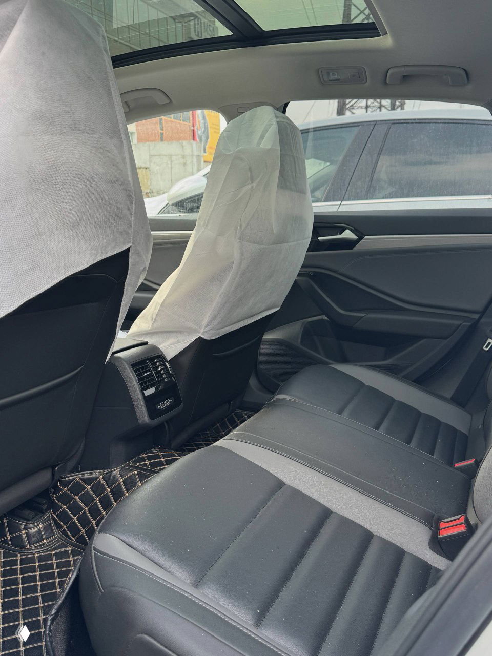 Задние сиденья Volkswagen Sagitar, просторный салон и отделка кресел; кадр показывает состояние задней части интерьера после доставки.