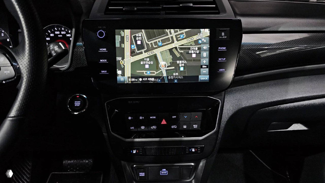 Центральная мультимедийная консоль Tivoli с включённой навигацией и элементами управления климатом; крупный экран показывает карту и меню.