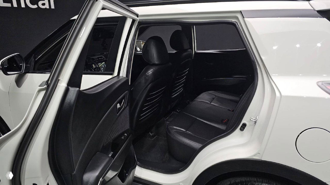 Задний ряд сидений SsangYong Tivoli — чёрная обивка, пространство для пассажиров и открытая задняя дверь для показа салона и доступа.