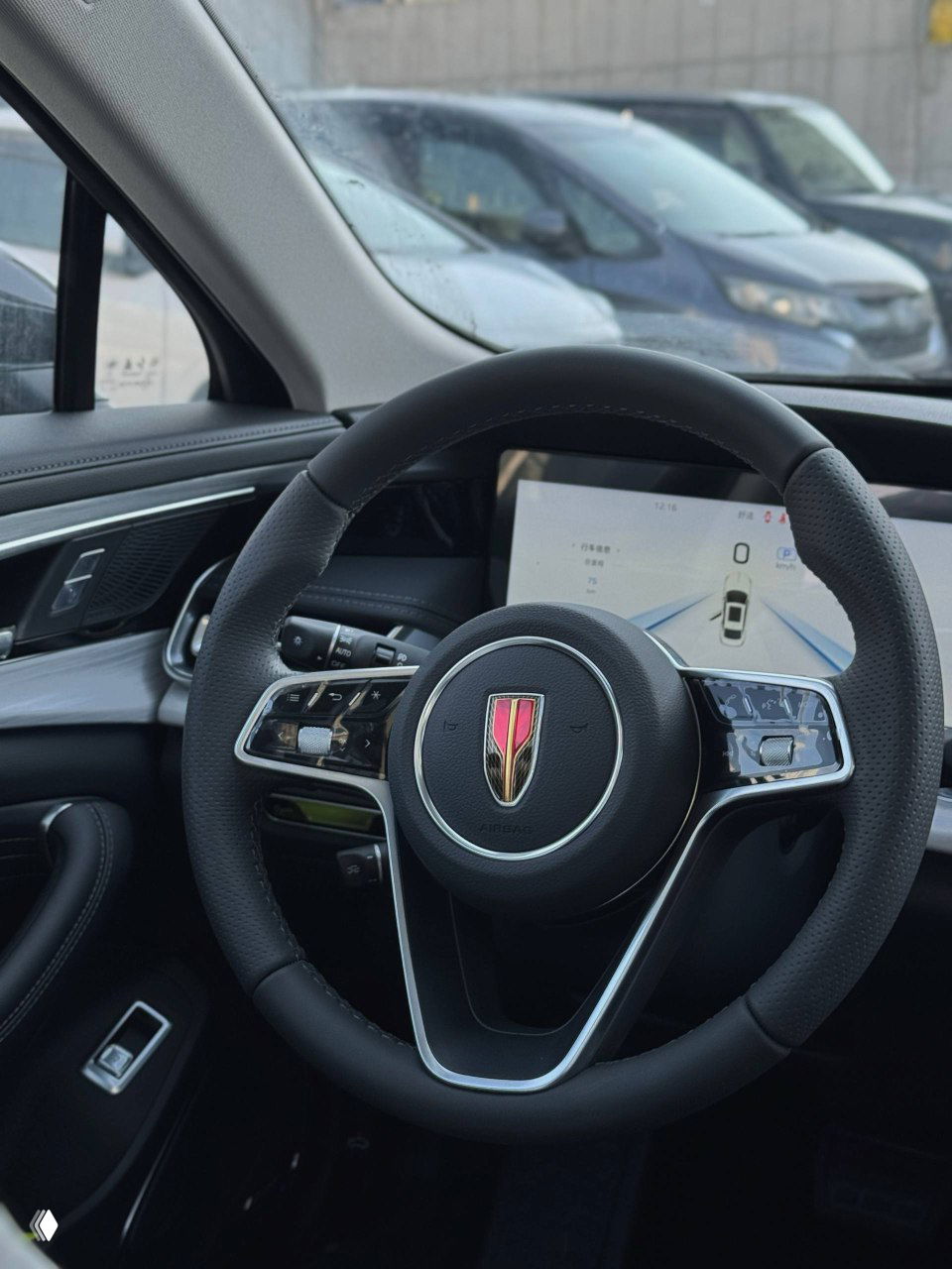 Крупный план рулевого колеса с логотипом Hongqi и частью приборной панели; интерьер новой машины с защитными плёнками на элементах.