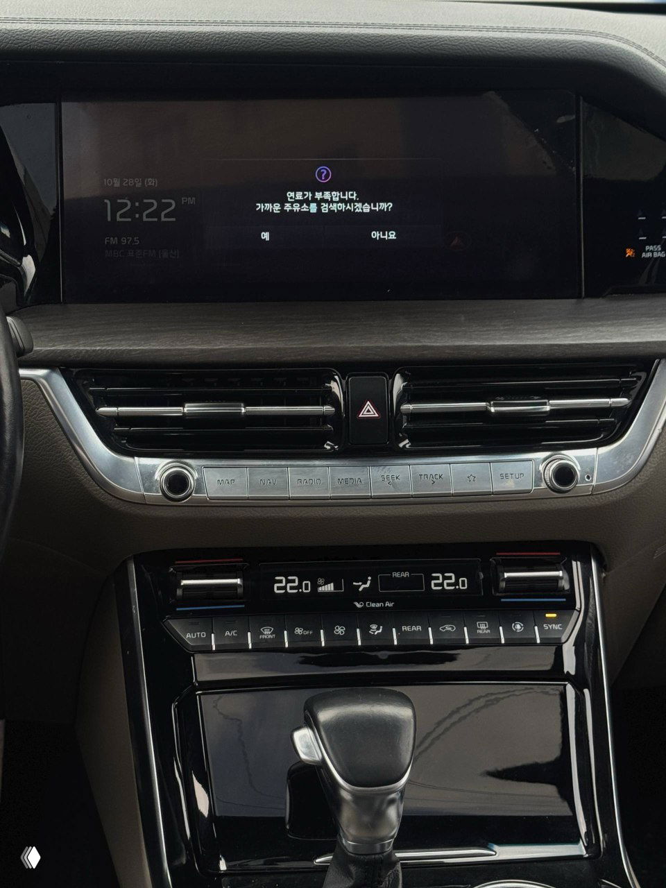 Центральная консоль KIA Mohave с мультимедийным экраном и блоком климат‑контроля, вид на рычаг переключения передач и панель.