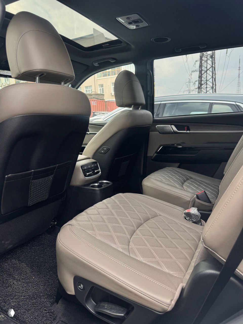 Задние сиденья KIA Mohave: крупный план на отделку сидений, иллюстрация пространства для пассажиров и ремней безопасности.