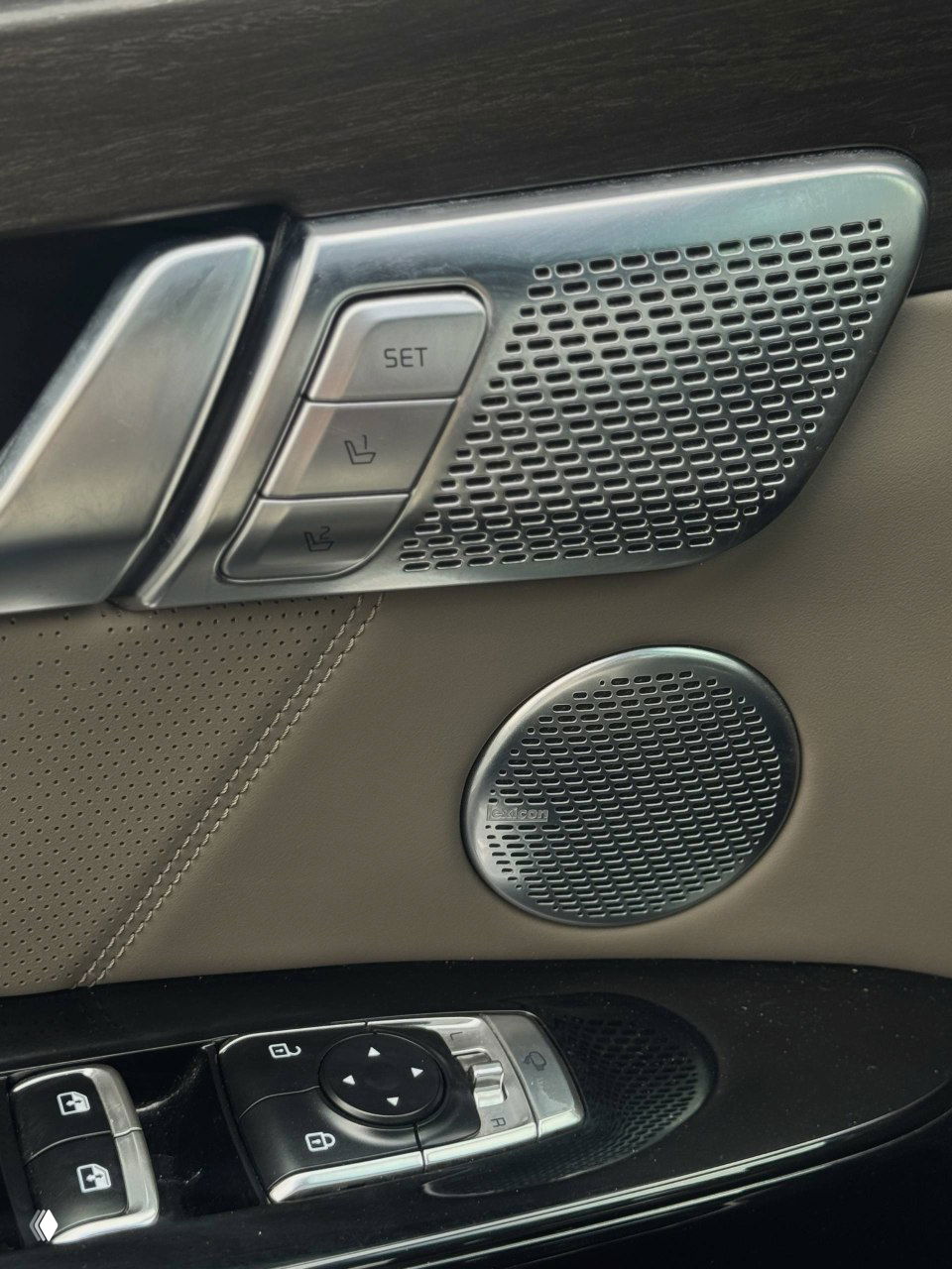 Детали дверной обшивки KIA Mohave: кнопки памяти сиденья, декоративная вставка и динамик, акцент на отделке салона высокого класса.