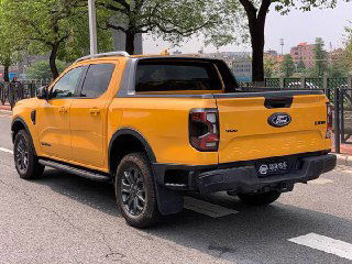 Крупный план задней части жёлтого Ford Ranger 2023 на парковке, видна задняя дверь кузова, фонари, бампер и номерной блок, фото для объявления.