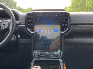Вертикальный сенсорный экран мультимедийной системы Ford Ranger в центральной консоли, на экране и вокруг видна отделка и элементы управления.