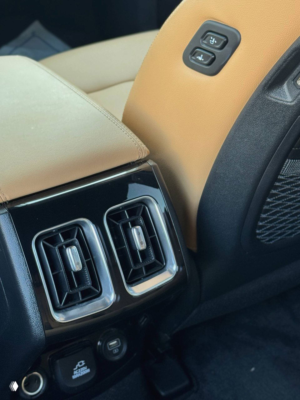 Крупный план задней вентиляции и розеток KIA Sorento — вид на воздуховоды, USB-разъёмы и элементы отделки багажного отсека, бежевый интерьер.