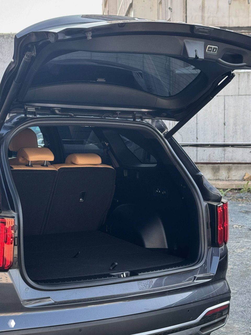 Открытый багажник KIA Sorento — вид внутрь грузового отсека с поднятой крышкой, ровная погрузочная площадка и складывающиеся сиденья заднего ряда.