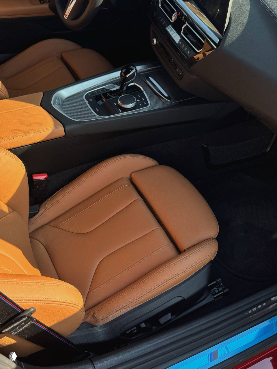 Вид на салон BMW Z4: передние сиденья из коричневой кожи, подлокотник и часть центральной консоли с селектором передач.