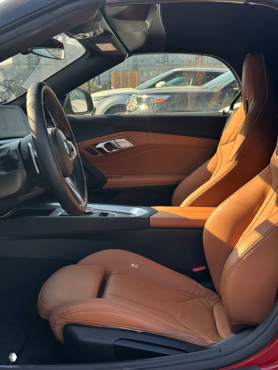 Внутренний вид пассажирского пространства и водительского сиденья BMW Z4, декоративная строчка и профиль спортивного кресла в солнце.