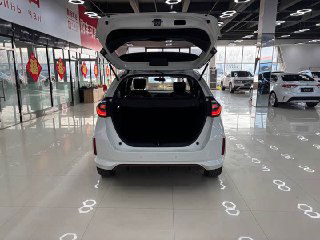 Открытый багажник белого Honda Life 2021 в салоне: вид на объем багажного отделения, погрузочный порог и отделку с внутренним освещением.