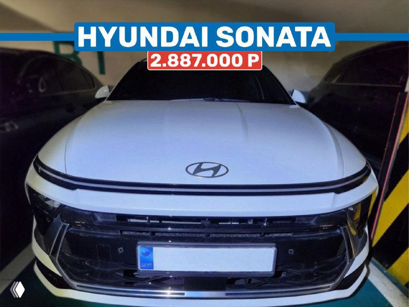 Крупный план передней части белого Hyundai Sonata в паркинге; видна решётка, фары и наклейка с ценой 2 887 000 р на верхней части фото.