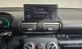 Крупный план центральной консоли Hyundai Casper: штатная магнитола, цифровые часы, воздуховоды и панель управления климатом — съёмка показывает практичный функциональный интерьер.