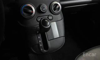 Крупный план селектора передач и нижней части центральной панели Hyundai Casper: рычаг АКПП, рукоять и элементы управления климатом на чёрной декоративной панели.