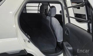 Перегородка за передними сиденьями и вид в салон Hyundai Casper: защитная решётка для груза, задняя часть сидений и свободное пространство для перевозки вещей.