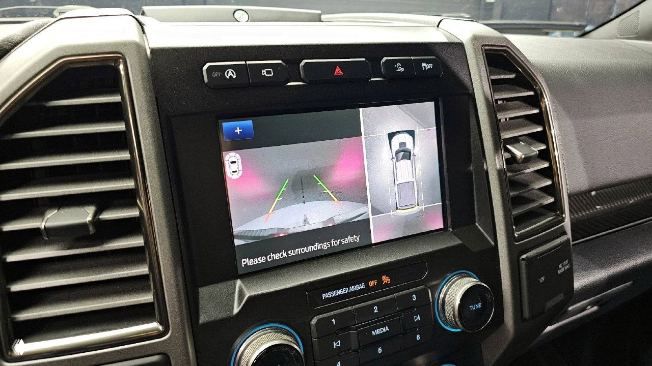 Экран мультимедиа с отображением камеры и обзором вокруг автомобиля в салоне Ford F-150 Raptor, детальный вид интерфейса парковки